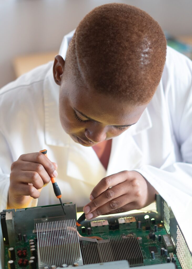 woman of colour with short hair working on a circuit board